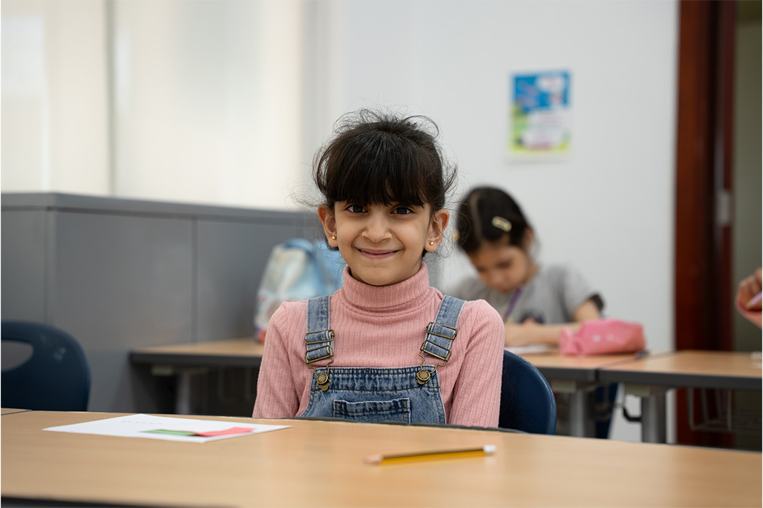 Smiling child participating in a Sandooq Al Watan activity